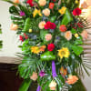 Tall standing floral spray with roses and bright mixed blooms