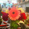 Bright mixed bouquet with a pink gerbera daisy in a glass vase