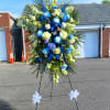 Large standing floral spray with blue and white flowers on an easel