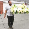 Man holding a large white floral spray with ribbons and butterflies