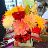 Bright mixed bouquet with a red rose, gerbera daisy, lilies, and chrysanthemums in a gift box.