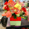Bright mixed bouquet with roses, lilies, and carnations in a red box