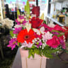 Bright mixed bouquet in a pink gift bag with roses and daisies