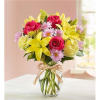 Bouquet of pink roses and yellow lilies in a clear glass vase