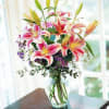 Pink stargazer lilies arranged in a clear glass vase