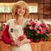 Woman holding a pink mixed flower bouquet with roses and lilies