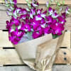 Bouquet of purple orchids wrapped in brown paper