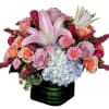 Pink lilies, roses, hydrangea, and daisies in a black square vase
