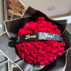 Large bouquet of red roses wrapped in black paper with a "I Love You!" ribbon