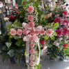 Pink carnation cross on a stand with a ribbon bow