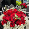 Bouquet of red roses with white baby's breath in black wrapping