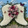 Large white floral funeral spray with pink and purple flowers and butterflies