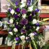 Purple and white floral standing spray on an easel