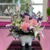 Pink and purple flower arrangement in a unicorn-shaped vase