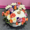 Pumpkin-shaped centerpiece with mixed roses, carnations, and white daisies