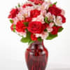 Red and pink mixed bouquet in a red glass vase