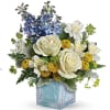 White roses and blue flowers in a blue cube vase