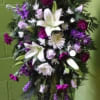 Tall standing floral spray with white lilies and purple flowers