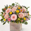 Pink roses and daisies arranged in a wooden box