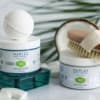 Two hair care jars with a brush and comb on a white surface