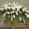 White floral arrangement with roses and lilies in a clear vase