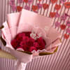 Bouquet of red and pink roses wrapped in pale pink paper