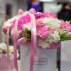 Pink and white flower arrangement in a white hatbox with ribbon