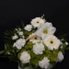 White flowers and green blooms arranged in a wicker basket