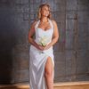Bride in a white gown holding a small bouquet of white calla lilies