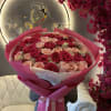 Large bouquet of pink and blush roses wrapped in bright pink paper