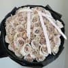 Bouquet of pale blush roses wrapped in black paper with white ribbons