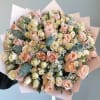 Large bouquet of blush and cream roses wrapped in pale pink paper
