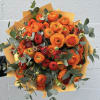 Bouquet of orange and red ranunculus with eucalyptus in orange wrap