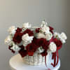 Basket of red and white roses with small white flowers