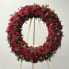 Circular wreath of red roses on a wooden stand