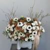 Large bouquet of white and brown roses with white anemones in a gray vase