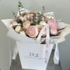 Blush pink and white bouquet with ribbon in a white gift bag