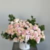 Large bouquet of pale pink roses and ranunculus in a white vase
