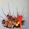 Autumn floral arrangement in a white pedestal vase with orange ribbon