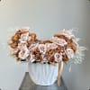 Arrangement of pale pink and tan roses in a white vase