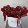 Red rose bouquet with orchids in a white gift box