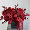 Red rose bouquet with poppies in a black vase