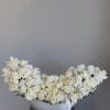 Large white rose arrangement in a white bowl vase