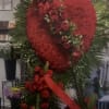 Heart-shaped red floral standing tribute with roses and ribbon
