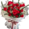 Bouquet of red roses wrapped in white paper with a ribbon