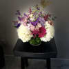 Mixed bouquet of white, pink, and purple flowers in a glass vase