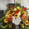 Large mixed flower arrangement with a white ribbon bow