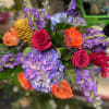 Bouquet of roses, hydrangea, and purple blooms in bright mixed colors