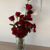 Tall arrangement of red roses in a clear ribbed vase
