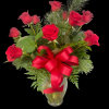 Red roses arranged in a clear glass vase with a red ribbon bow